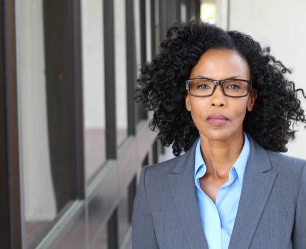 Professional Black Woman wearing business suit;signs you are being micromanaged at work, signs you are working in a hostile work environment, signs you are working in a culture of fear, signs you are working in a culture of silence, signs you are working in a toxic team, signs you are working for a toxic boss Twanna Carter anxiety catastrophic thinking