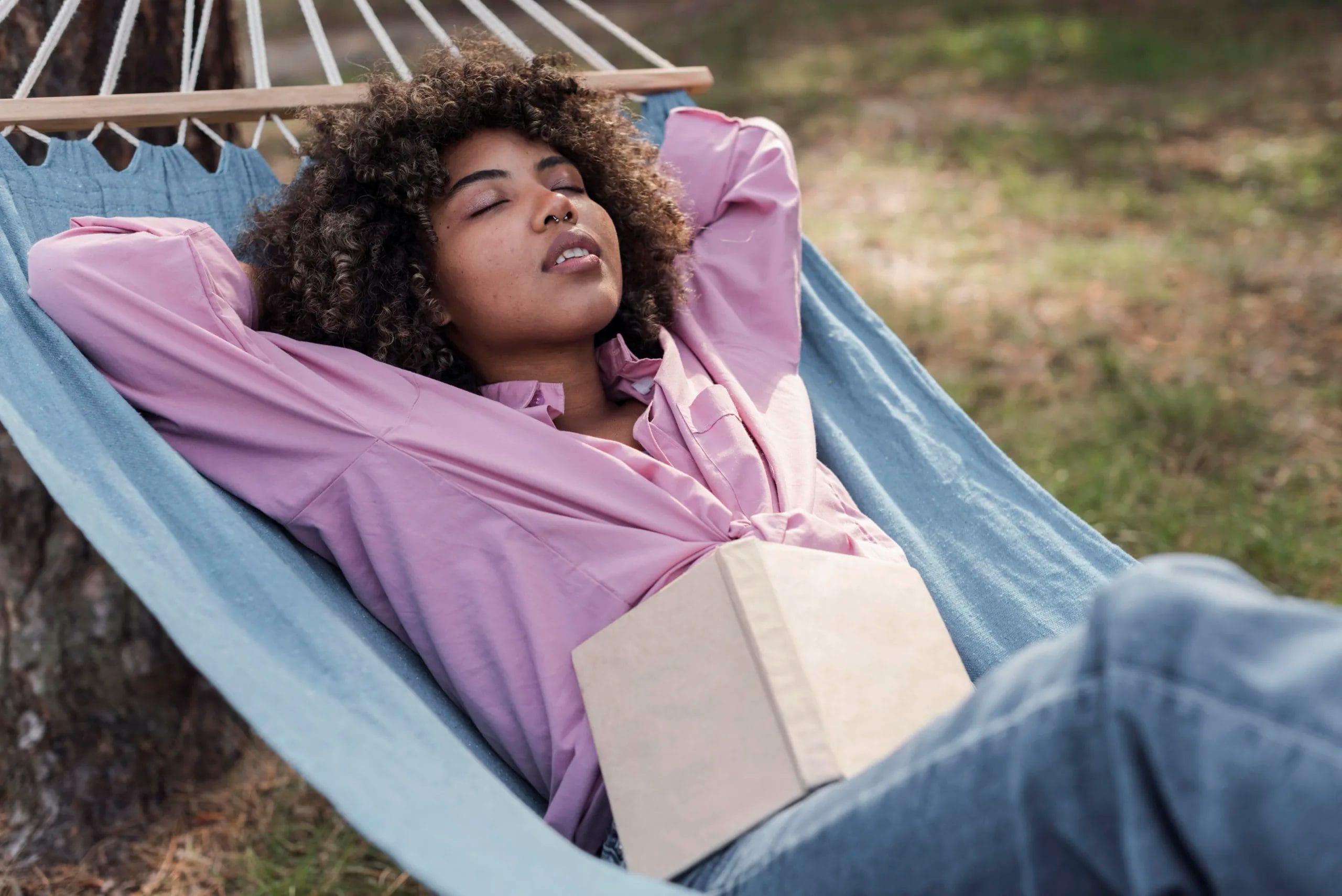 woman-relaxing-hammock-while-camping-outdoors-with-book; overcome burnout, burnout, overcoming burnout, how to overcome burnout, signs of burnout, symptoms of burnout, finding balance, work life balance, work=-life balance; reignite your passion, passion, Black woman, career coach, confidence coach