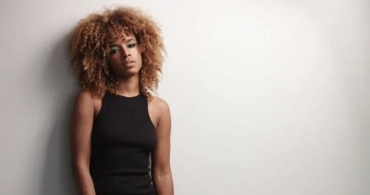 Pretty black girl with big hair posing video. on grey background; sabotaging your success; inner critic